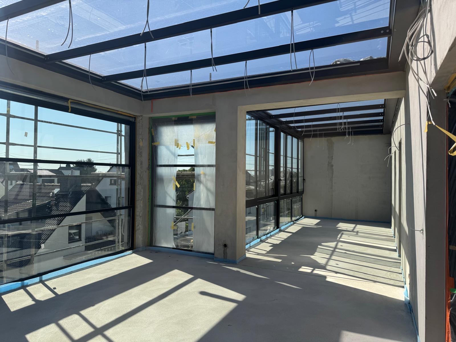 Verglaster Terrassenanbau mit Eckverglasung und Glasdach an einem Wohnhaus